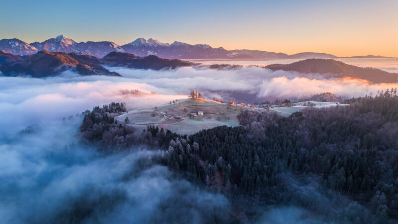 Golden Sunrise Behind Slovenian Mountain Church wallpaper 4K