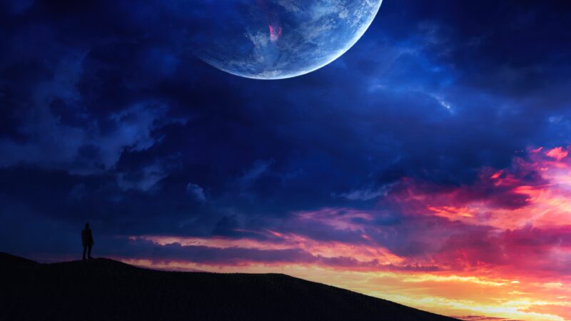 Man on Dune Beneath a Dreamy Planet Sky wallpaper 4K